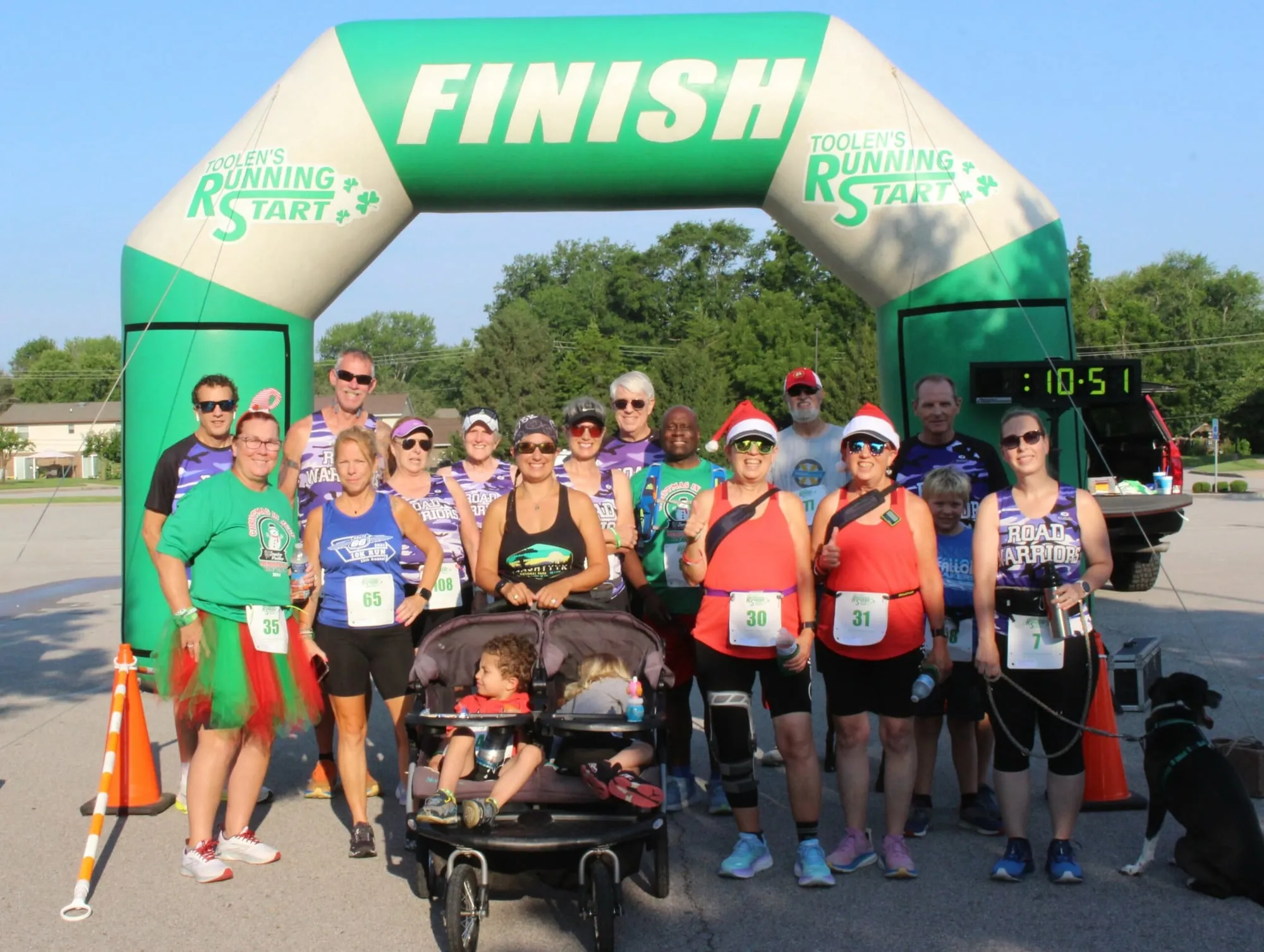 Runners and families in green shirts gathered under the finish arch at the Jennifer Mueller Memorial 5K.