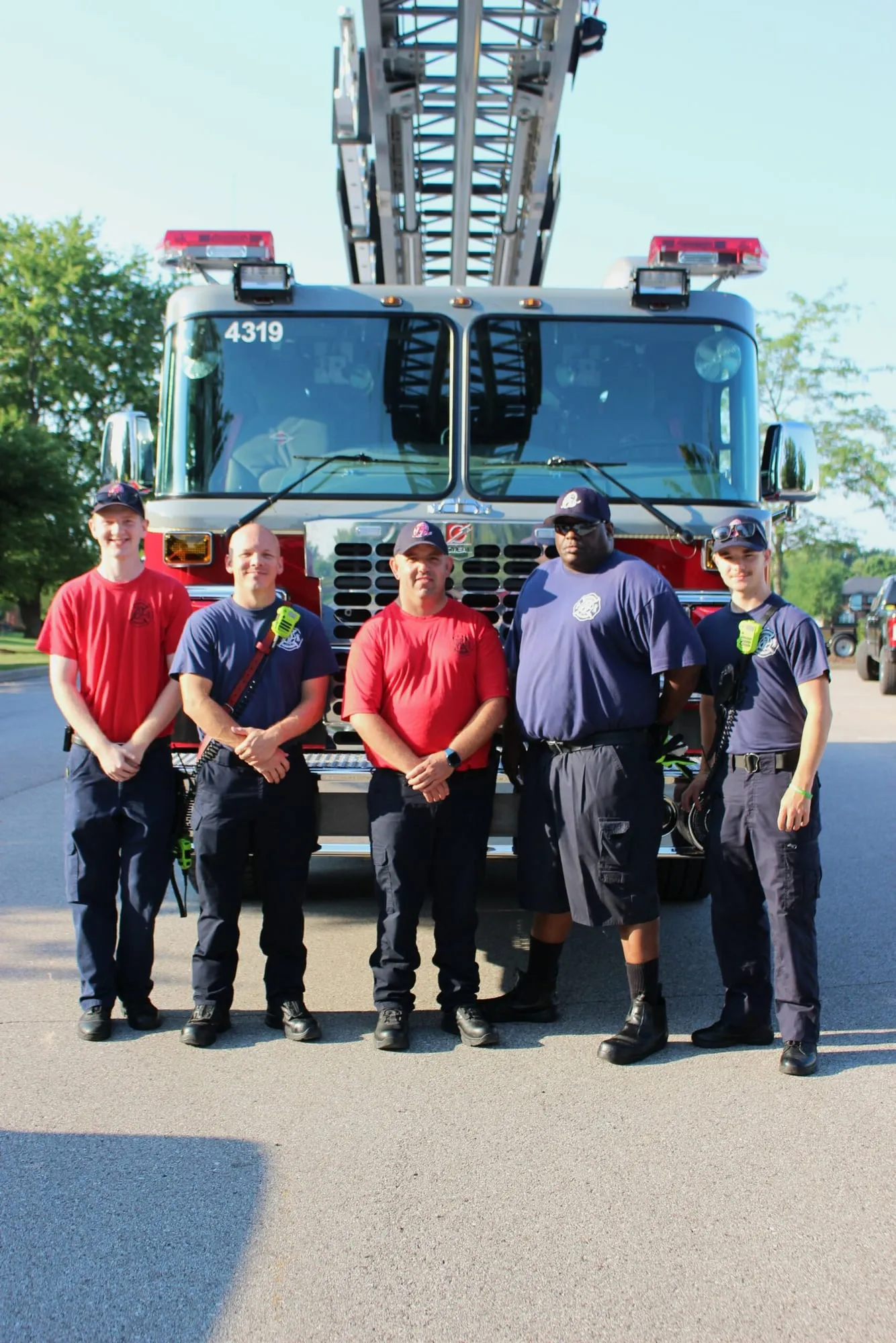 Four O’Fallon firefighters standing in front of their engine at the race.