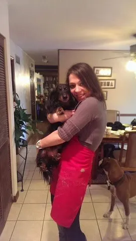 Jennifer Mueller at home, holding her dachshund.