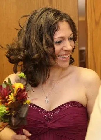 Jennifer Mueller, smiling, holding a bouquet.