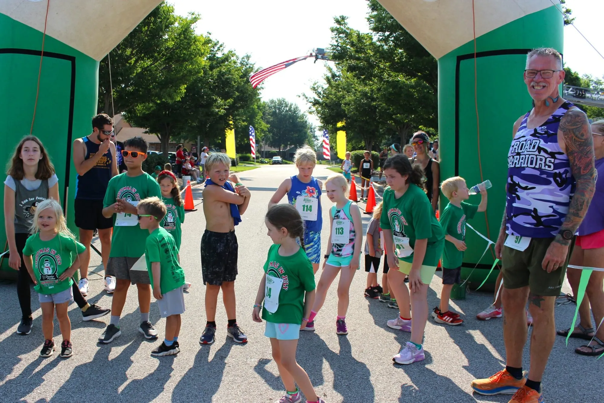 Young children lined up and taking off from the start line of the Kids Fun Run.