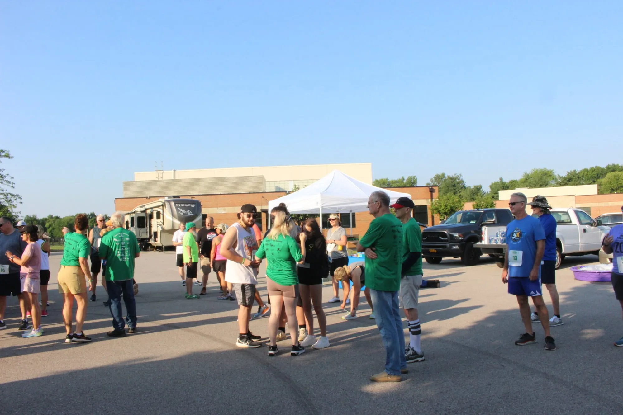 Runners and families gathered in the parking lot before the race, tents in the background.