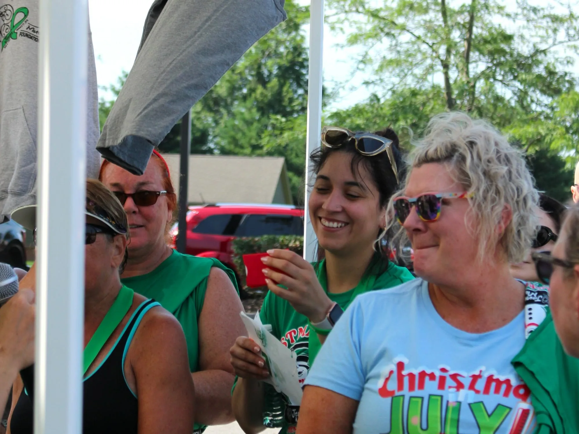 Three women laughing together at the post-race tent.